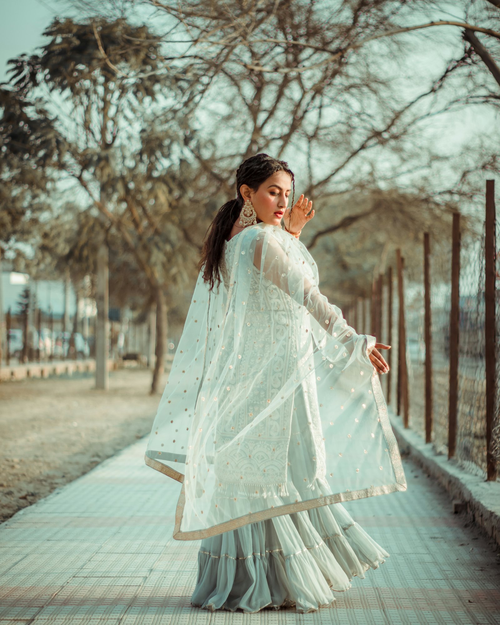 Ivory chikankari kurta with a tiered sharara and gold-bordered net dupatta