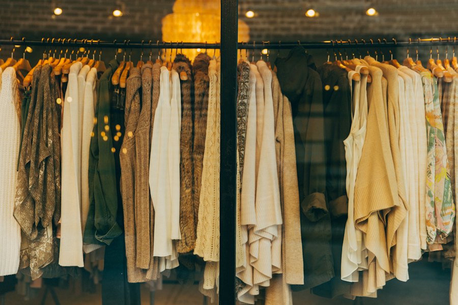 Olive cotton overshirt hanging between oatmeal and camel knits