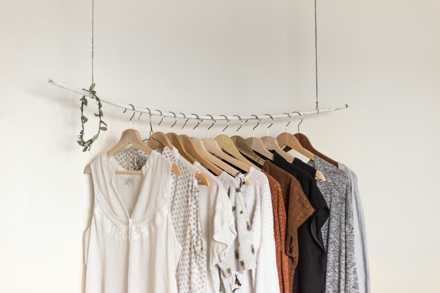 Grey melange, black and rust knit tees hanging on wooden hangers