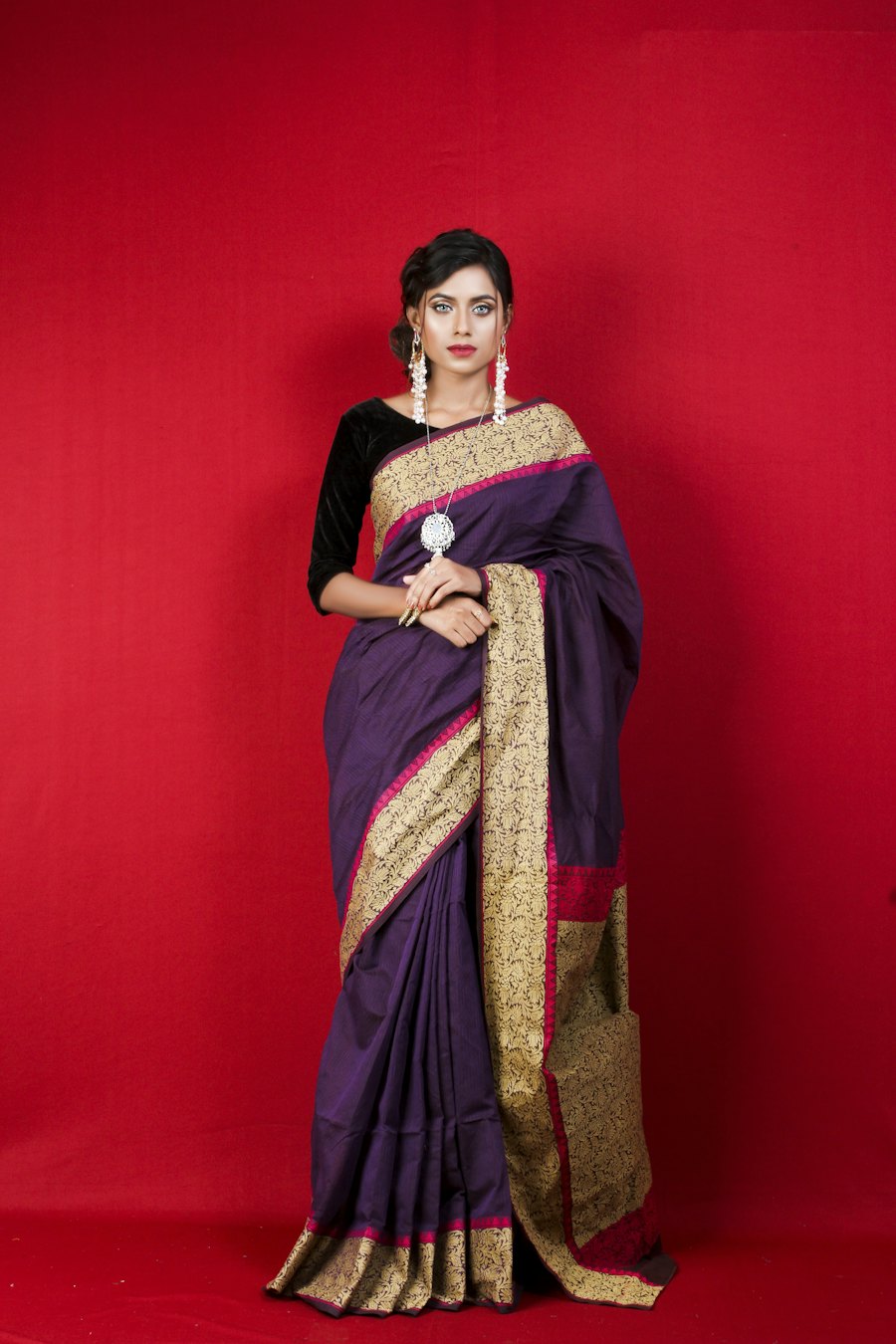 Aubergine silk saree with a wide gold zari border and pink piping