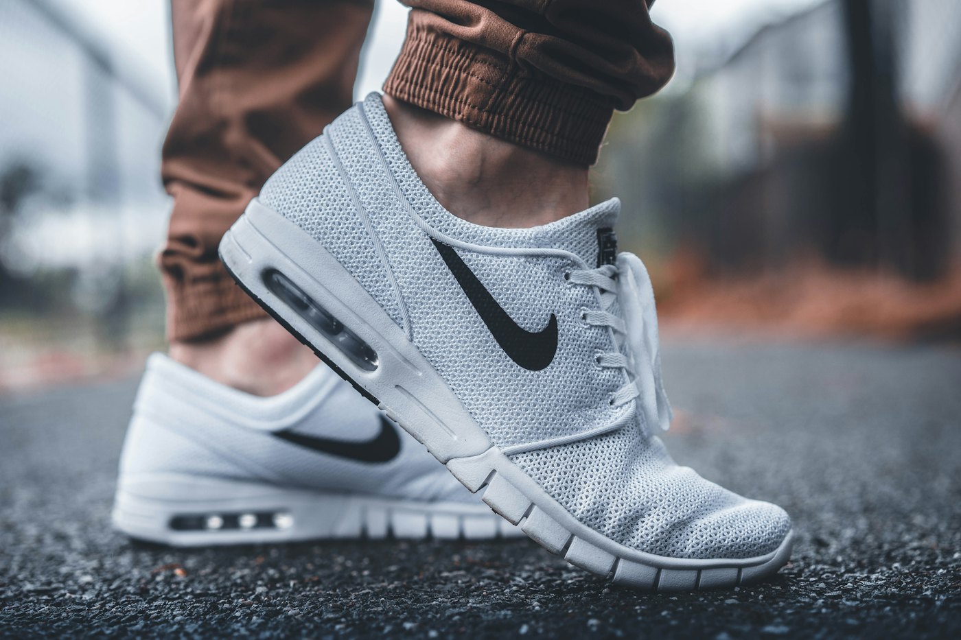 Close-up of someone walking down a road in grey and white mesh sneakers