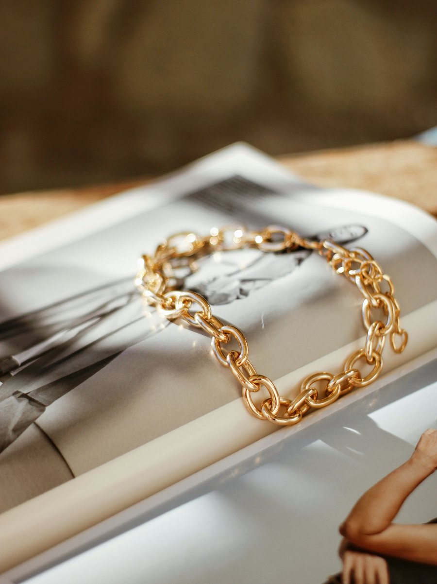 Chunky gold chain-link bracelet resting on an open book
