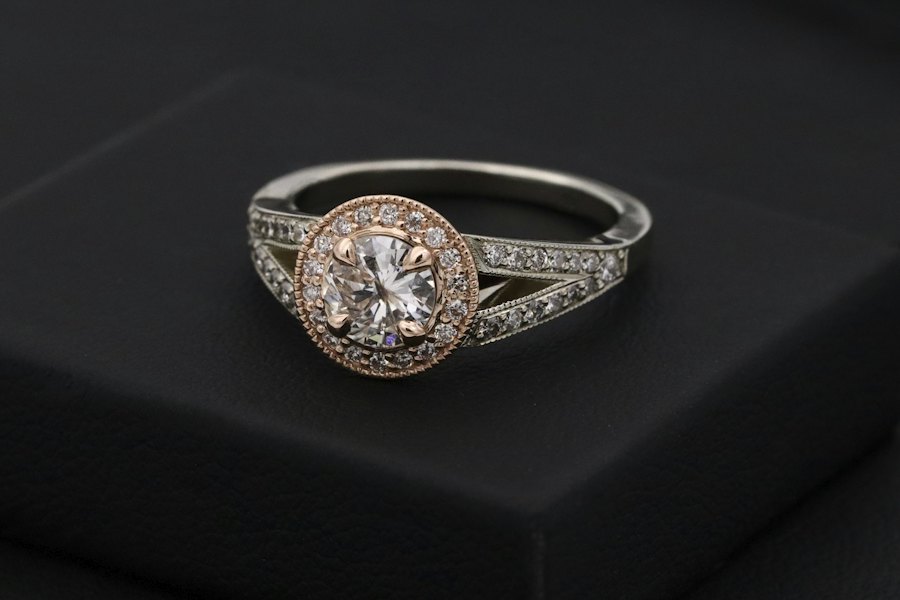 Diamond halo ring on a black stand