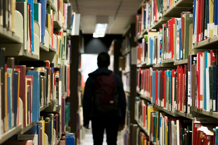 A long library aisle between tall shelves full of books